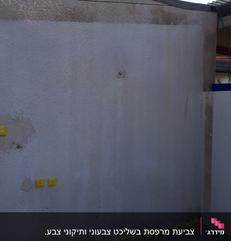 קיר עם סימני תיקון, סרט דבק צהוב, מגש צבע